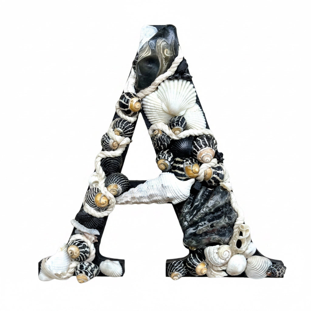 A Black and white initial-Classic, bold and beautifully coastal, handmade with sea shells and decorative rope. An unframed personalised coastal keepsake ideal for a new baby nursery, bedroom decor or door sign, available in all letters and made to order.