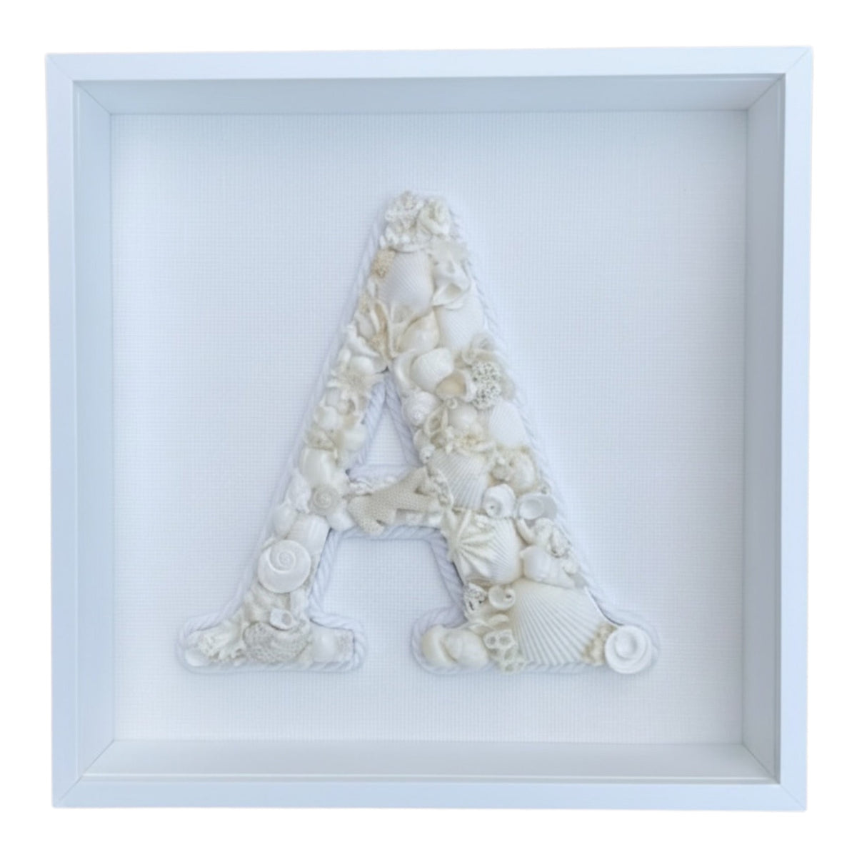 Creamy white seashell initial in a white shadow box frame