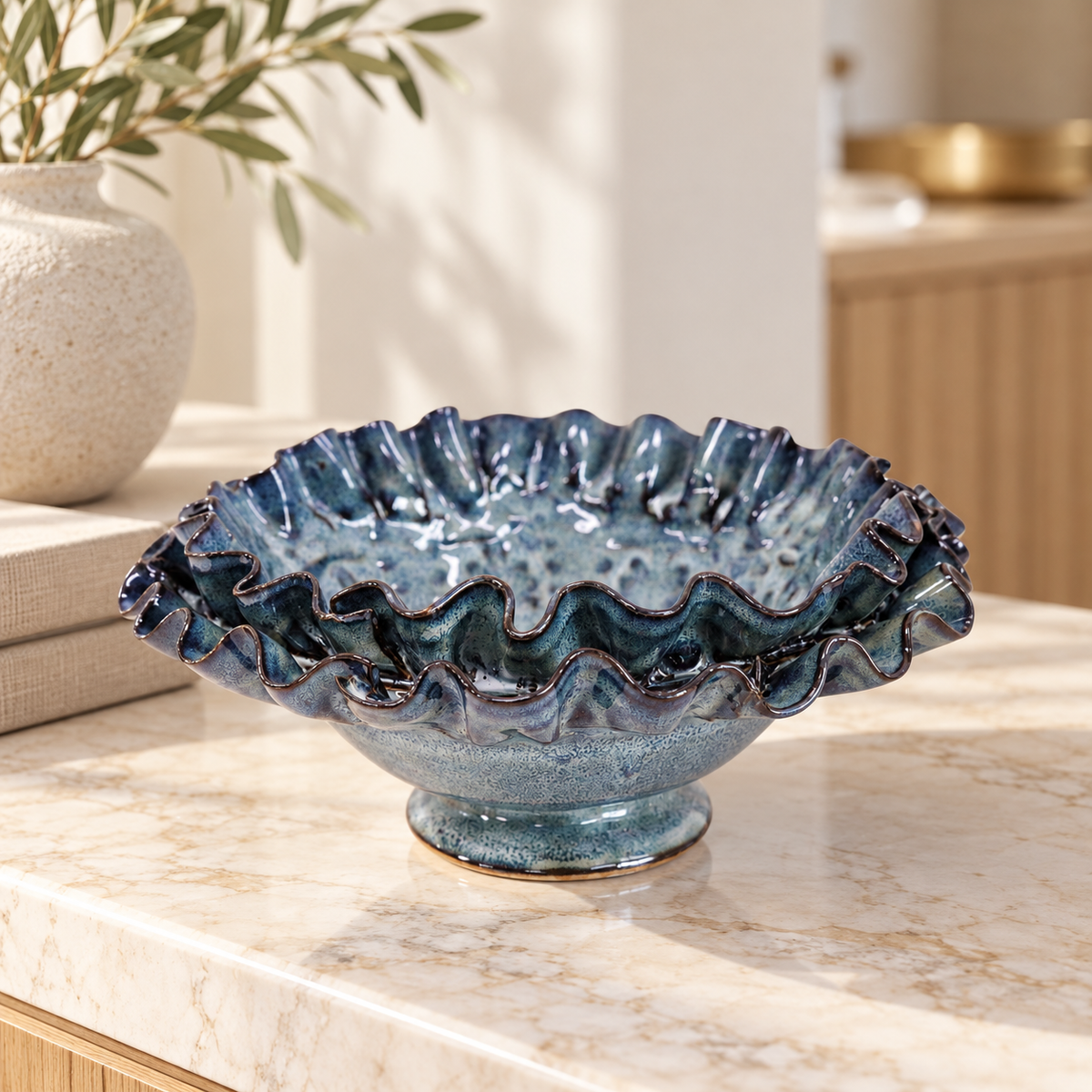 Azure French blue decorative ruffled ceramic bowl styled on an ivory marble console in a coastal home