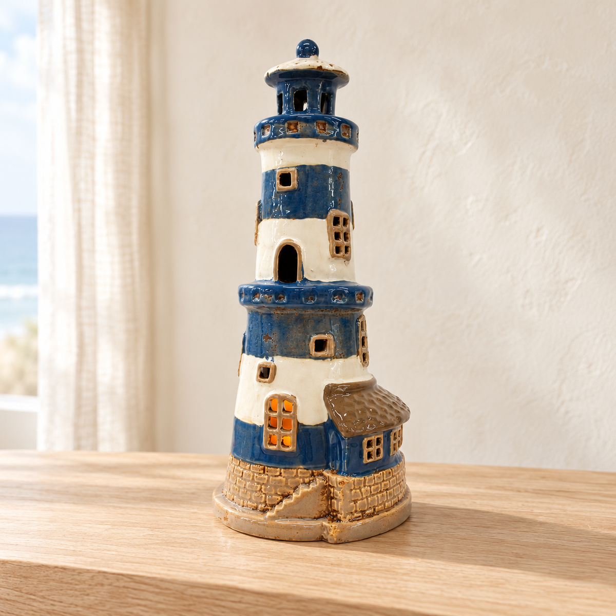 Beacon Cove blue and cream lighthouse décor styled on a pale oak console with an ivory coastal backdrop