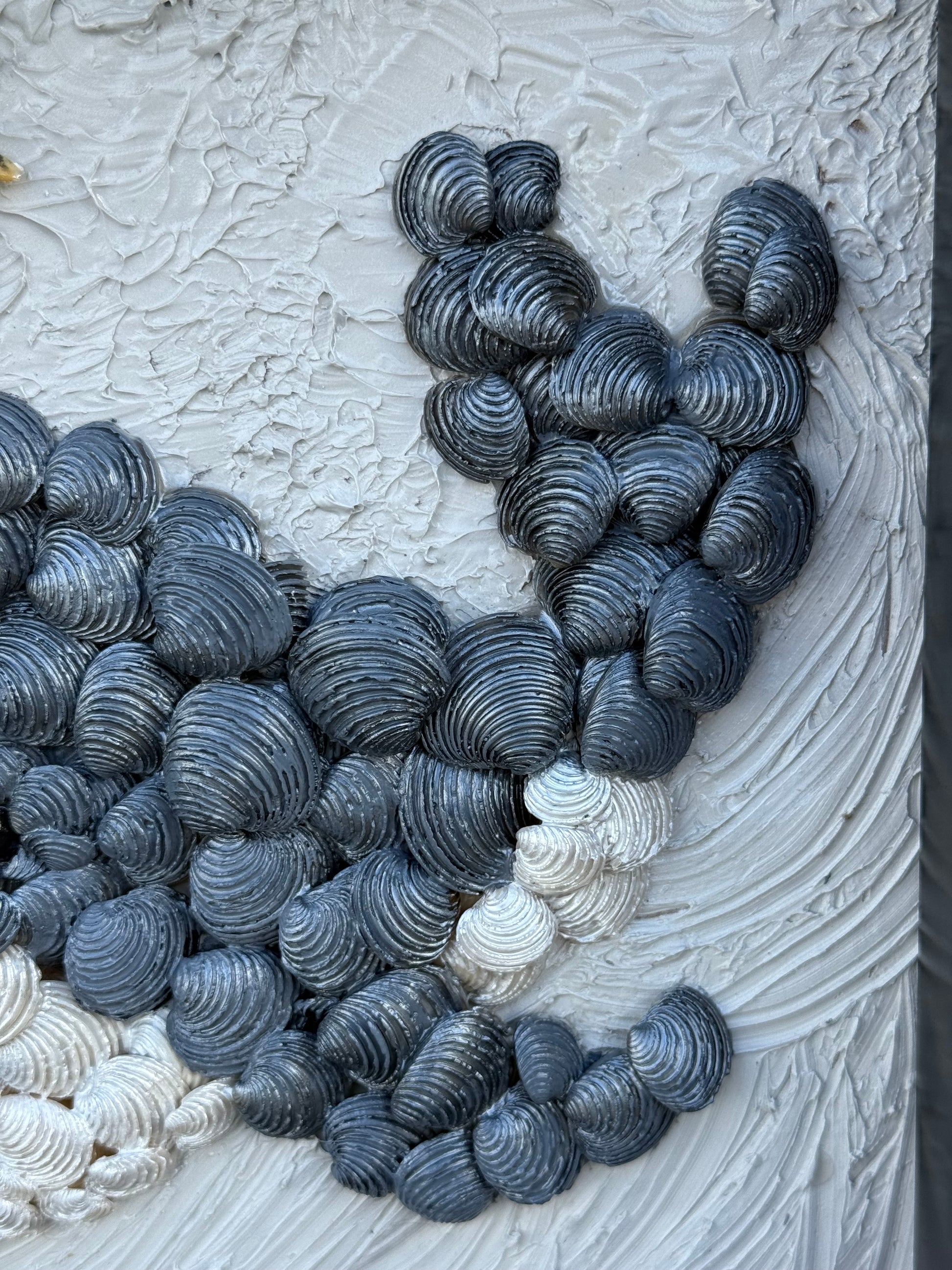 Close up of Decorative handmade coastal whale wall art, black white grey with golden spout shells, framed seashell keepsake bedroom decor gift