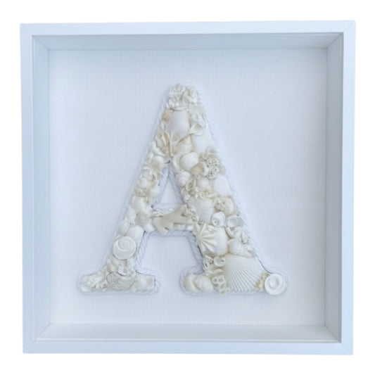 Handmade framed shell art initial created creamy white natural seashells in a white deep shadow box frame. A personalised coastal hamptons keepsake ideal for baby nursery or bedroom decor, available in all letters and made to order.
